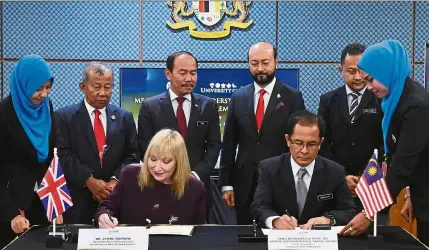  ??  ?? (From second left, standing) Prof Sudin, Dr Ismail, Mukhriz and Prof Cairul Iqbal witness the signing of the MoU between Prof Ahmad Bashawir (seated, right) and Barrow. - Bernama