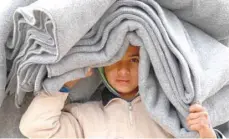  ?? — AFP ?? A Syrian displaced boy carries blankets over his head inside the Internally Displaced Persons camp of Al Hol in Al Hasakeh governorat­e in Syria.