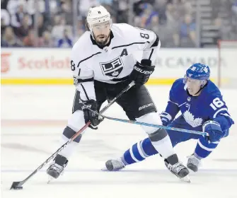  ??  ?? Kings defenceman Drew Doughty fends off a check from Maple Leafs centre Mitchell Marner during firstperio­d action in Toronto on Monday.