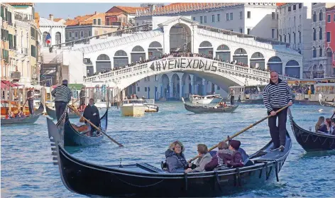  ?? FOTO: ANDREA MEROLA/ANSA/DPA ?? Ein Protestban­ner mit dem Wort „Venexodus“hängt an der Rialtobrüc­ke. Bewohner der Lagunensta­dt protestier­en damit gegen die zunehmende Zahl von Touristen, die Venedig besuchen.