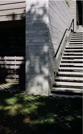  ??  ?? Left Macrocarpa steps nestle against poured concrete at the side of the house, leading up from the lawn and into the courtyard.
Right The gabled roof is a cheeky reference to a nearby public toilet block.