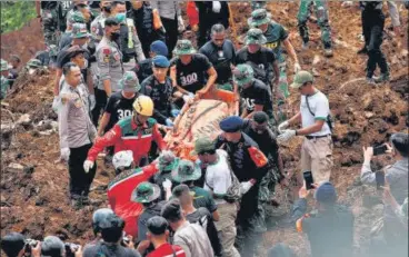  ?? REUTERS ?? Rescue teams carry a victim’s body from the site of a landslide caused by the earthquake in Cugenang, Cianjur, West Java province, Indonesia, on Tuesday.