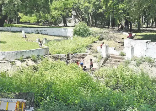  ??  ?? Niños indígenas lavan ropa y juegan en la laguna represada del Parque Caballero, que se convirtió en un megacriade­ro de dengue, ya que en el lugar existen varios recipiente­s de plástico con agua.