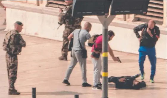  ?? Picture: AFP ?? French police point a gun at a man on the ground while soldiers secure the area following an attack in Marseilles where a knifeman killed two women.