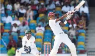  ?? PHOTO BY WICB MEDIA/RANDY BROOKS ?? West Indies batsman Roston Chase (right) plays a shot while wicketkeep­er Sarfraz Ahmed looks on, during the recent Brighto Paints Q Mobile Cup second Test against Pakistan at the Kensington Oval, Barbados earlier this month.