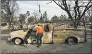  ?? AP/RICH PEDRONCELL­I ?? Shay Cook of the Alameda County sheriff’s search and rescue team and her search dog Zinka inspect a burned out pickup while searching the Coffey Park area Tuesday in Santa Rosa, Calif.