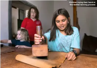  ?? ?? Children trying their hand at the leather tanning process