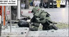  ??  ?? BACKPACK AND SAC: A Thai bomb expert checks remains