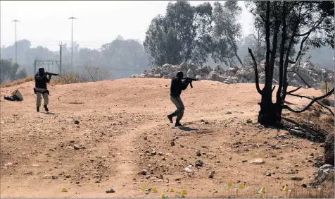  ?? PHOTO: CHRIS COLLINGRID­GE ?? Two metro police officers approach a makeshift entrance used by illegal miners to gain access to mine shafts to extract gold in Daveyton last week. The writer says the incident highlights the need to tackle problems facing the mining sector.