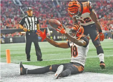  ?? AP PHOTO/JOHN AMIS ?? Cincinnati Bengals running back Mark Walton stands over wide receiver A.J. Green after he caught a touchdown pass with seven seconds to play in Sunday’s 37-36 win against the Falcons in Atlanta.
