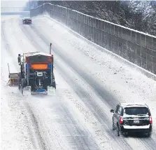  ?? PHOTOS: DAN JANISSE ?? Top: Emergency crews respond to a motorist who spun out into the snowy E.C. Row Expressway median near Dominion Boulevard Sunday. Bottom left: A heavy equipment operator clears snow on Labelle Street after Windsor declared a citywide snow emergency....