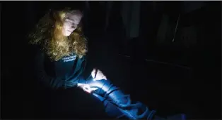  ??  ?? In the dark, with only the glow from her recorder to break up the night, Margo Griffin listens to one of the audio recordings containing some unusual sounds.