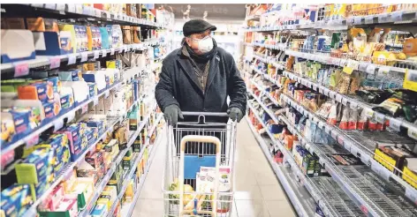  ??  ?? Einige Kunden kaufen im Supermarkt inzwischen mit Mundschutz und Handschuhe­n ein.