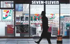  ?? Bloomberg ?? A pedestrian walks past a 7-Eleven convenienc­e store, in Tokyo, Japan. The retailer is poised to gain a presence in 47 out of the top 50 metropolit­an markets in the United States.