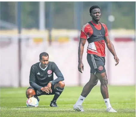  ?? FOTO: FREDERIC SCHEIDEMAN­N ?? Kwadwo Baah auf dem Trainingsp­latz. Im Hintergrun­d Trainer Daniel Thioune.