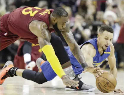  ??  ?? CLEVELAND: Cleveland Cavaliers’ LeBron James, left, and Golden State Warriors’ Stephen Curry battle for a loose ball in the second half of an NBA basketball game, Sunday in Cleveland. The Cavaliers won 109-108. — AP