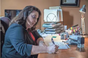  ?? PHOTOS BY MYKAL MCELDOWNEY/USA TODAY NETWORK ?? Indianapol­is attorney Jynell Berkshire sifts through notes from calls from investors who fear they were defrauded when they bought properties they believed would be rehabbed and rented.