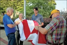  ?? Jeremy stewart ?? Brewster-Cleveland American Legion Post 86 Commander Kenneth Roberts (from left), Polk County Commission­er Gary Martin, state Rep. Trey Kelley, and Polk County Commission Chairman Hal Floyd work to fold the new American flag for Cedartown’s Veteran’s Memorial Park on Wednesday, July 28, 2021.