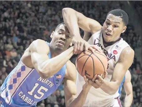  ?? Lee Luther Jr. Associated Press ?? VIRGINIA TECH’S Kerry Blackshear Jr., right, fights for a rebound with North Carolina's Garrison Brooks, who appears to get to the ball first. Blackshear scored 16 points in the Hokies’ 80-69 upset victory over the No. 10 Tar Heels at Blacksburg, Va.
