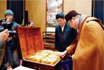  ??  ?? January 17, 2017: Shan (center) and eminent monk Master Yanzang check on the scriptures of Tripitaka. Prints of the complete version of an 18th century edition of the Tripitaka, a collection of Buddhist scriptures, have been collated by the Palace...