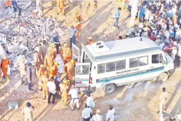  ??  ?? Members of the National Disaster Response Force (NDRF) remove a victim from the rubble after an under constructi­on building collapsed in the village of Shah Beri village in Greater Noida in Uttar Pradesh.