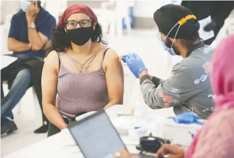  ?? JASON PAYNE FILES ?? A woman receives a COVID-19 vaccinatio­n from a nurse at the Dukh Nivaran Sahib Gurdwara in Surrey. Fraser Health has launched several unique initiative­s to address the community's high rate of COVID-19 infection.