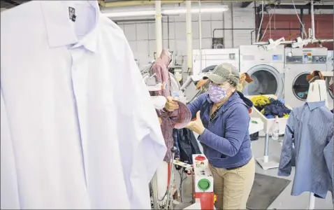  ?? Paul Buckowski / Times Union ?? Best Cleaners presser Sandra Thomas operates a double-buck automated shirt press at the State Street production facility on Tuesday in Schenectad­y. There is still some demand for dry cleaning but, since the pandemic, business is markedly down.