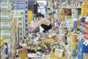  ?? REUTERS ?? Staff remove bottles knocked down by the quake at a shop.