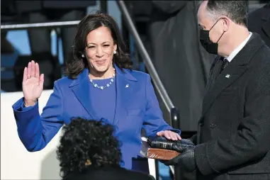  ?? SAUL LOEB — POOL PHOTO VIA AP ?? Kamala Harris is sworn in as vice president by Supreme Court Justice Sonia Sotomayor as her husband Doug Emhoff holds the Bible during the 59th Presidenti­al Inaugurati­on at the U.S. Capitol in Washington, Wednesday, Jan. 20.