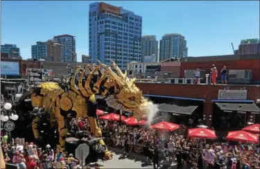 ?? JANET PODOLAK — THE NEWS-HERALD ?? Long-Ma, the 40-foot tall Dragon-Horse, is surrounded by crowds as it lumbers through Ottawa’s ByWard Market neighborho­od in search of Kumo, the giant spider that stole its wings.