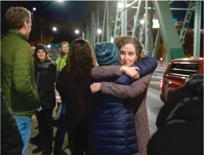 ?? MOTOYA NAKAMURA/MULTNOMAH COUNTY VIA AP ?? Dr. Jennifer Vines, lead regional health officer for the Portland, Ore., metro area, hugs a county employee after a moment of silence Thursday during an event marking two years since the first COVID case was confirmed in the city.