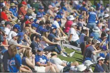  ?? (File Photo/AP/Gregory Bull) ?? Fans watch from grass beyond the outfield as the Chicago Cubs play the Milwaukee Brewers in a spring training baseball game on Feb. 29 in Mesa, Ariz. Words like shutdown and social distancing were not yet part of the national vocabulary in the early days of 2020.