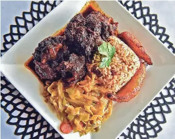  ?? HANNAH MATTIX/CLARION LEDGER ?? Fall-off-the-bone oxtail served with coconut rice, peas, stir-fried cabbage and sweet plantains is seen at Sambou's African Kitchen in Jackson, Mississipp­i, on Feb. 28.