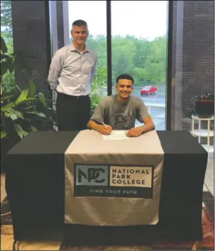  ?? Submitted photo ?? PLAYER OF THE YEAR: Jessievill­e’s Alex Burleson, seated, recently signed with coach Jason Hudnell and the National Park College men’s basketball team.