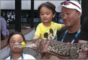  ?? COURTESY OF TENNIS AUSTRALIA ?? Retired tennis pro Michael Chang and his children meet a crocodile during the Australian Open on Jan. 16.