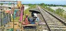  ?? - PTI ?? FLOOD-AFFECTED: Flood victims take refuge beside a railway line in Katihar district of Bihar on Friday.