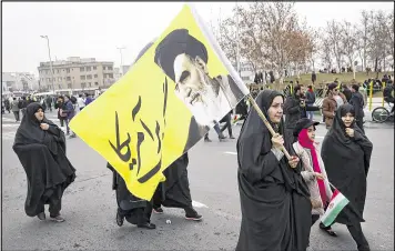  ?? VAHID SALEMI / ASSOCIATED PRESS ?? A woman carries a banner with a portrait of the late revolution­ary founder Ayatollah Khomeini and a “death to America” slogan in Persian at an annual rally Friday in Tehran, Iran, to mark the anniversar­y of the 1979 Islamic revolution.