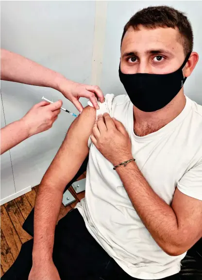  ??  ?? THIRD TIME LUCKY: Ethan Ennals rolls up his sleeve to receive the jab… for the third time this year