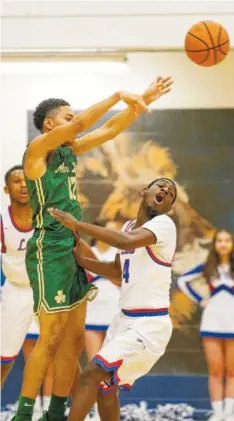  ?? STAFF PHOTO BY DOUG STRICKLAND ?? Notre Dame’s Bryson Smith passes over Red Bank’s Jemichal Holland during Tuesday’s game at Red Bank High School. Notre Dame won 53-44.