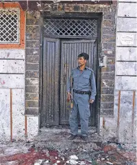  ?? RAHMAT GUL/THE ASSOCIATED PRESS ?? An Afghan police officer stands Sunday outside a voter registrati­on center that was attacked by a suicide bomber in Kabul, Afghanista­n. Gen. Daud Amin, Kabul police chief, said the suicide bomber targeted civilians who had gathered to receive national...