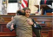  ?? Rogelio V. Solis / Associated Press ?? GOP Sen. Briggs Hopson and Democratic Sen. Albert Butler hug after the vote to change the state flag.