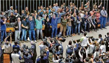  ??  ?? Pedindo intervençã­o militar e saudando o juiz Sergio Moro, manifestan­tes comemoram invasão de plenário da Câmara