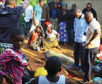  ?? The Associated Press ?? Family members and onlookers mourn over bodies of civilians killed by The Allied Democratic Forces rebels in Beni, Eastern Congo. Congo military said Sunday that rebels attacked an Ebola treatment centre in Beni, leaving over a dozen civilians dead and abducted about a dozen children, which could force crucial virus containmen­t efforts to be suspended in the area.