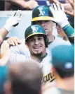  ?? Charles Rex Arbogast / Associated Press ?? Matt Olson, left, circles the bases after his homer in the first; Jaycob Brugman, center, is greeted after his shot in the second; and Franklin Barreto, right, celebrates a blast in the third.