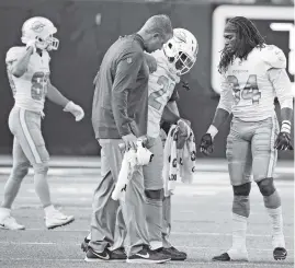  ?? CHARLES TRAINOR JR. ctrainor@miamiheral­d.com ?? Dolphins running back Frank Gore is helped off the field after sustaining a sprained foot against the Vikings on Sunday. Gore, 35, might have played his last NFL game.