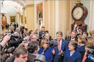  ?? AP PHOTO ?? A group of senators gather off the Senate floor to speak to reporters after reaching an agreement to advance a bill ending a government shutdown on Capitol Hill in Washington, Monday, Jan. 22, 2018. From left are, Sen. Tim Kaine, D-Va., Sen. Heidi...