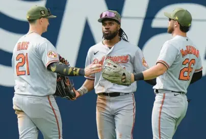  ?? FRANK GUNN/AP PHOTOS ?? From left, Orioles left fielder Austin Hays, center fielder Cedric Mullins and right fielder Ryan McKenna celebrate after an 8-3 win over the Blue Jays on Sunday in Toronto.