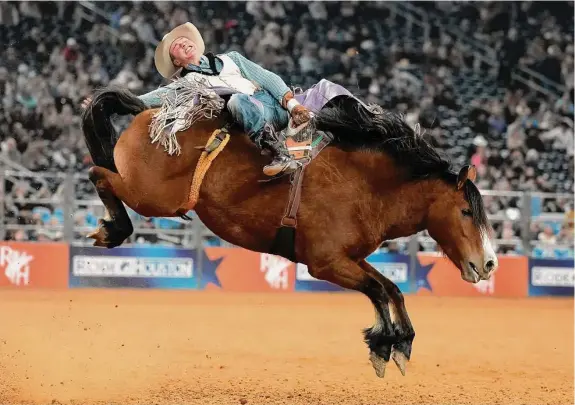  ?? Karen Warren/Staff photograph­er ?? Sam Petersen rides Topped Off in the bareback riding competitio­n Saturday during RodeoHoust­on at NRG Stadium. Petersen advanced to the finals on a tiebreaker.