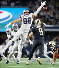  ?? AP Photo/Ron Jenkins ?? ■ New Orleans Saints quarterbac­k Drew Brees (9) is pressured by Dallas Cowboys defensive tackle Tyrone Crawford (98) as he passes during the second half of an NFL football game Thursday in Arlington, Texas.