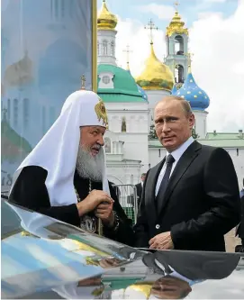 ?? Pictures: AFP ?? KING OF THE KREMLIN: President Vladimir Putin and Russian Orthodox Bishop Patriarch Kirill meet at a monastery outside Moscow, above; and below, a sticker bearing a picture of Putin decorates a urinal in a restaurant in the Ukrainian city of Lviv